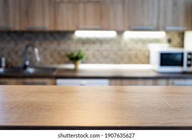 blurred kitchen interior and wooden desk space home background - Shutterstock ID 1907635627
