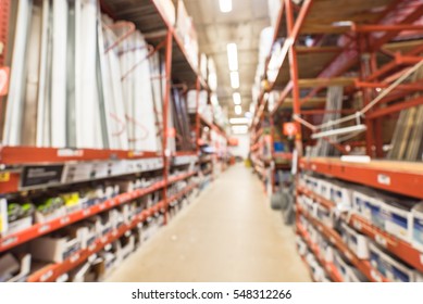 Blurred a large hardware store in America. Defocused interior home improvement retailer with racks of fence, gate, poultry mesh and gutter hardware and building materials from floor up to ceiling.