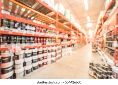 Blurred Large Hardware Store In America. Defocused Interior Home Improvement Retailer, Racks, Rows Of Interior Paint, Exterior Paint/stain, Floor Paint/stain Cans And Building Materials Up To Ceiling.