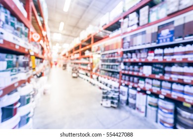 Blurred Large Hardware Store In America. Defocused Interior Home Improvement Retailer, Racks, Rows Of Interior Paint, Exterior Paint/stain, Floor Paint/stain Cans And Building Materials. Vintage Tone.