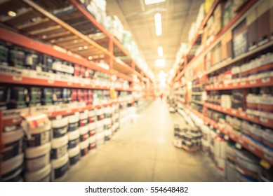 Blurred Large Hardware Store In America. Defocused Interior Home Improvement Retailer, Racks, Rows Of Interior Paint, Exterior Paint/stain, Floor Paint/stain Cans And Building Materials. Vintage Tone.