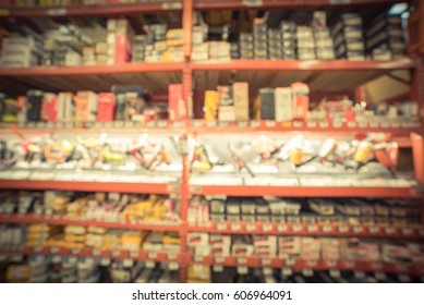 Blurred Large Hardware Store In America. Defocused Interior Home Improvement Retailer With Rack Of Framing, Straight, Gauge Cordless, Pneumatic Brad Nailer Kit, Stapler, Rope, Chain Tool. Vintage Tone