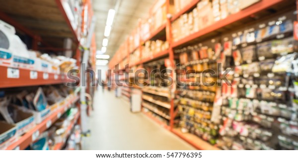 Blurred a large hardware store, tools and\
material. Defocused interior of home improvement retailer, racks of\
door hardware, weather proofing and lockset floor to ceiling.\
Customers shopping.\
Panorama
