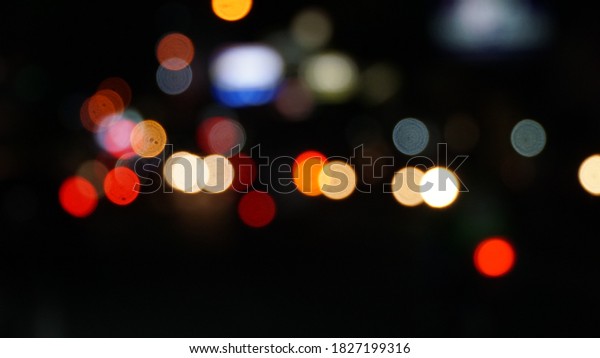 blurred\
light from car and motorcycle lights at\
night.
