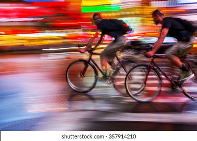 blurred lights on a night urban scene and cyclists silhouettes