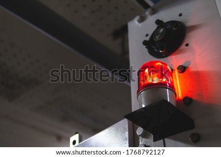 blurred low key Illuminated factory industry red alert emergency light with copy space for background. Attention concept, tragedy, emergency, safety and insurance