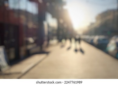 Blurred main street of a large Ukrainian city at sunset golden hour in winter with bright sun crowd of people walking down the street shops city center