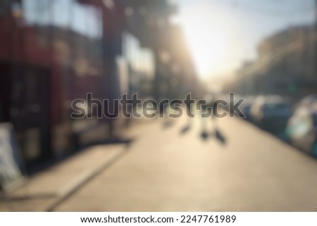 Blurred main street of a large Ukrainian city at sunset golden hour in winter with bright sun crowd of people walking down the street shops city center