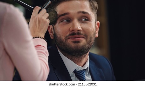 Blurred Makeup Artist Applying Face Powder On Smiling Man In Formal Wear