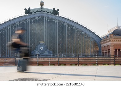 Blurred Man With Luggage Running To Catch A Train In Front Of The Madrid Atocha Train Station