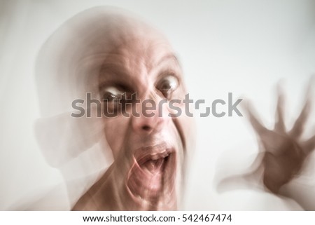 Blurred man suffering from dementia and insanity, opened hand, screaming, in moment of fury, hallucination