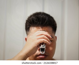 Blurred, Man Using Electric Hair Clipper For Self Hair Cut.