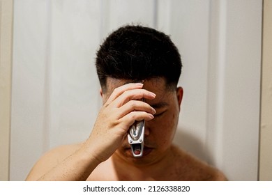 Blurred, Man Using Electric Hair Clipper For Self Hair Cut.