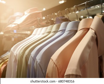 Blurred Mens Shirts In Different Colors On Hangers In A Retail Clothes Store