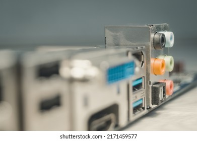 Blurred motherboard. Audio connectors on the back of the computer motherboard to connect external speakers and microphone. USB ports. Selective focus