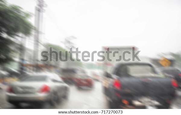 Blurred motion car on the road\
view through car window with rain drop during in rain traffic\
jam