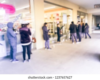 Blurred motion crowd of people waiting in line for store opening Black Friday hour in Carrollton, Texas, USA. Defocused abstract shoppers standing outside a department store for shopping deals
