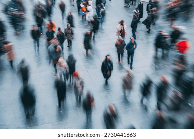 Blurred motion of a crowd of people walking on a paved surface