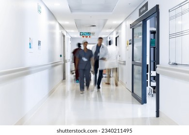 Blurred motion of diverse doctors and medical staff in busy hospital corridor, copy space. Hospital, medical and healthcare services. - Powered by Shutterstock