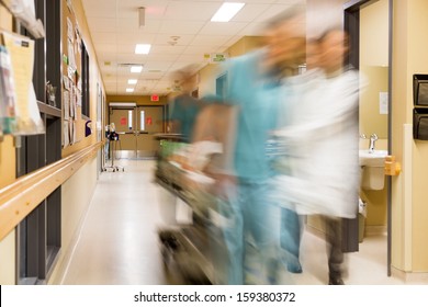 Blurred motion of doctor and nurse pulling stretcher in hospital