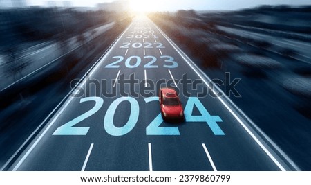 Blurred motion highway with red car, and new year number 2024, 2023 on the road