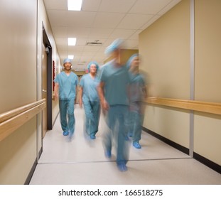 Blurred Motion Of Medical Team Walking In Hospital Corridor