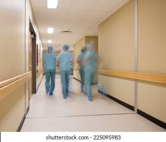 Blurred Motion Of Medical Team Walking In Hospital Corridor