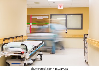 Blurred motion of nurses with stretcher walking in hospital corridor