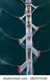 Blurred Motion Overhead View Of A Rowing Crew In A Sculling Boat On The Water, Mid Stroke