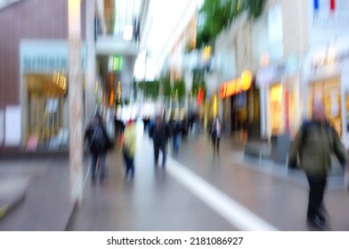 Blurred motion of people traveling in a city outside. Defocused on crowd population of tourists, travelers and pedestrians exploring abroad while walking in a bustling and busy urban street downtown