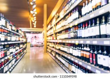 Blurred Motion Wine Shelves And Price Tags On Display At Grocery Store In Texas, USA. Defocused Rows Of Red, White Wine Liquor Bottles On Supermarket Shelf. Alcoholic Beverage Abstract Background