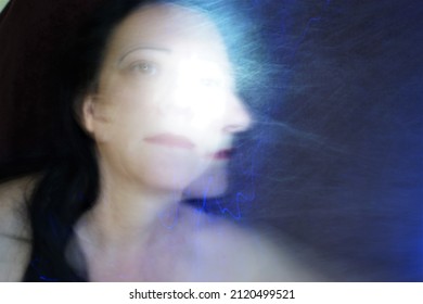 Blurred Motion Of Woman Portrait And Futuristic Blue Neon Light.