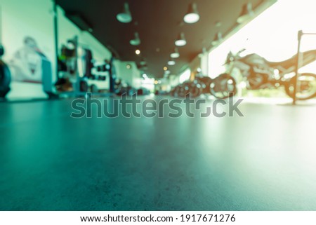 the blurred motorcycle showroom interior design with dark tone color, background product with a copy space