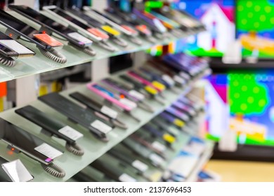 Blurred new smartphones stand in a row on a showcase in a store - Shutterstock ID 2137696453