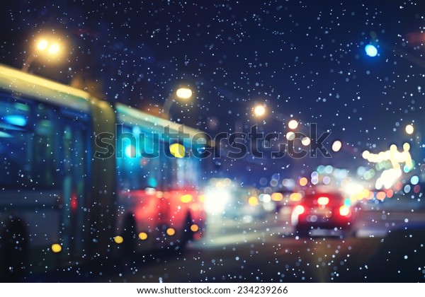 blurred night background city traffic road city\
lights winter snow\
glare