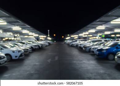 Blurred Night Time Parking Shopping Mall, Rows Of Parked Cars.