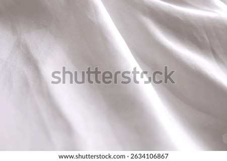 Blurred off white abstract pattern with a soft, silky fabric texture—reminiscent of satin—perfect for use as a backdrop, background, or textile design for fashion items like shirts, clothes and other 