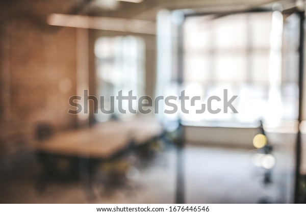 Blurred office interior space
background. Blurred interior of modern office workplace a workspace
design without partition decorate with black, white and wooden
furniture