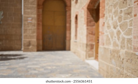 Blurred outdoor scene with brick walls, cobblestone path, and arches in a sunny urban area with a bokeh effect - Powered by Shutterstock