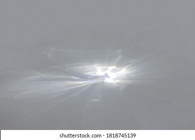 Blurred overlay effect for photo and product mockups presentation. Empty scene with gray background and organic drop shadows and rays of light. Natural rainbow light refraction caustic effect. 