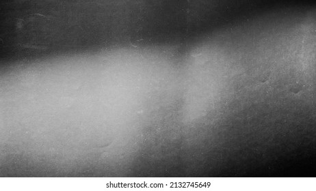 
					Blurred paper black gray light background.
					Grunge film grain effect distressed scary texture.