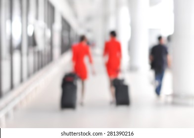 Blurred People And Flight Attendants Walking At The Airport Hallway