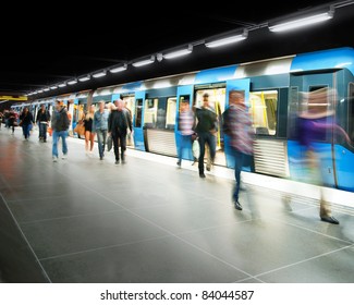 Blurred people on subway platform leaving the train