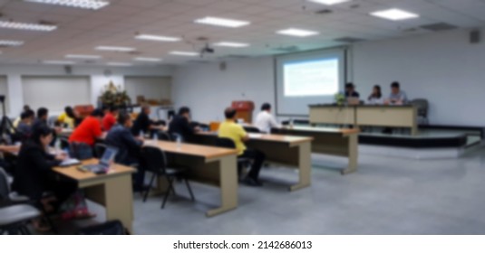 Blurred Of People Training In Room With Three Instructors, Listener And Projector. Seminar And Workshop. Group Of Personal Study And Learning In Classroom. Blur Focus Concept