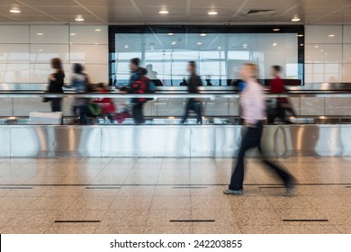 Blurred People Walking On Airport Walkway