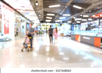 Blurred Of People Are Walking In Shopping Mall Or Department Store With Bokeh Background. Blurry Background Of Dad With Baby Stroller And Couples Are Walking In Mall For Shopping And Relax In Holiday.