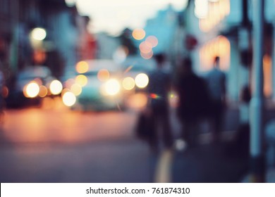 Blurred people walking through a city street