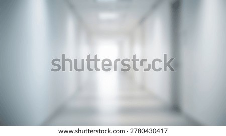 A blurred perspective shot of a long, empty hospital corridor with white walls and bright lighting. The image evokes a sense of cleanliness and sterile environment.