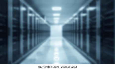 A blurred perspective view down a long aisle in a modern data center server room, illuminated by overhead lights.