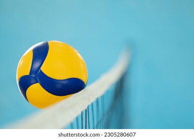 Blurred photo in action of a volleyball near the net. Playing volleyball, ball reaching opponents side of the net - Powered by Shutterstock